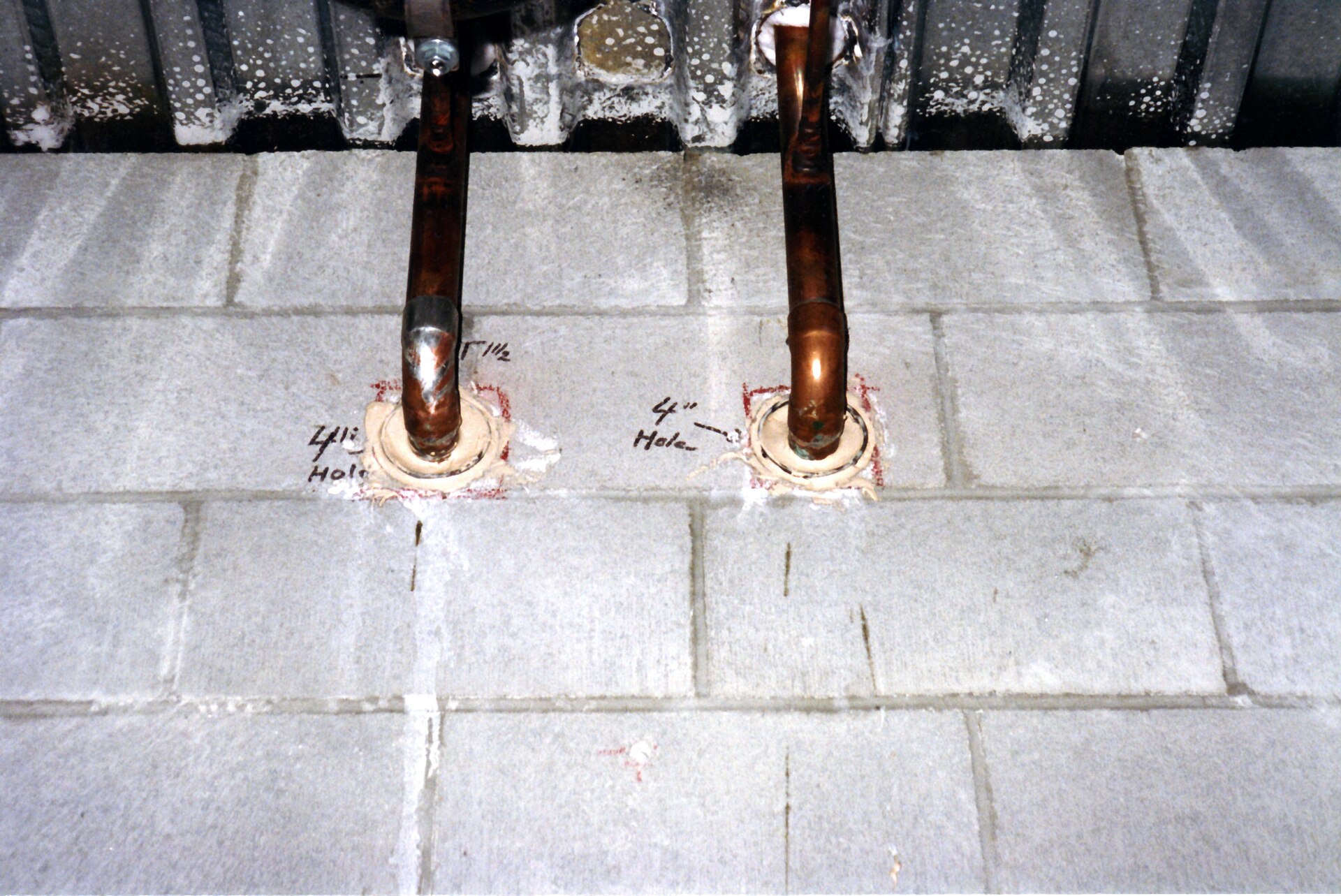 Copper pipes running through a concrete block wall